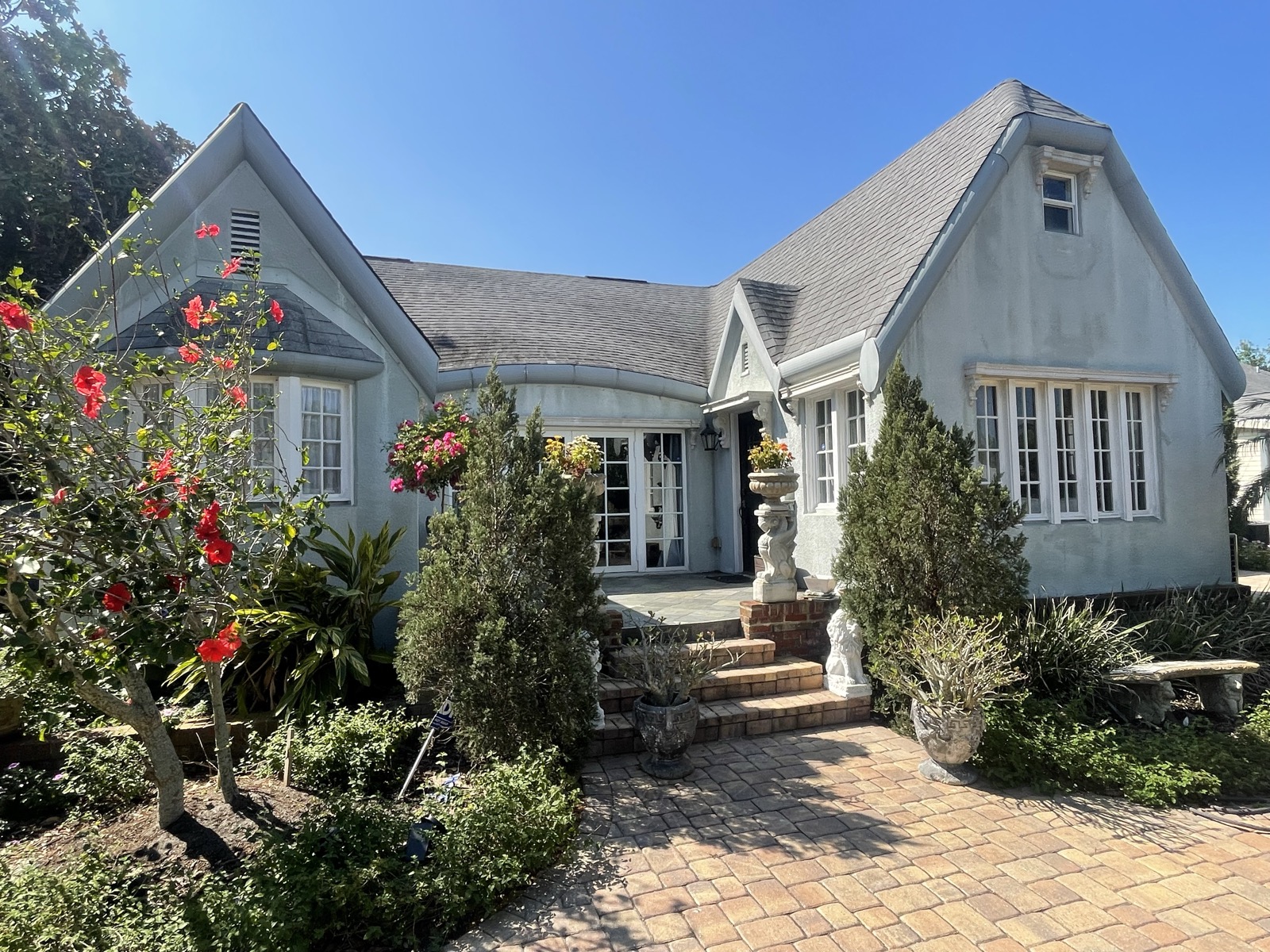 Gray Tudor-style cottage before repaint