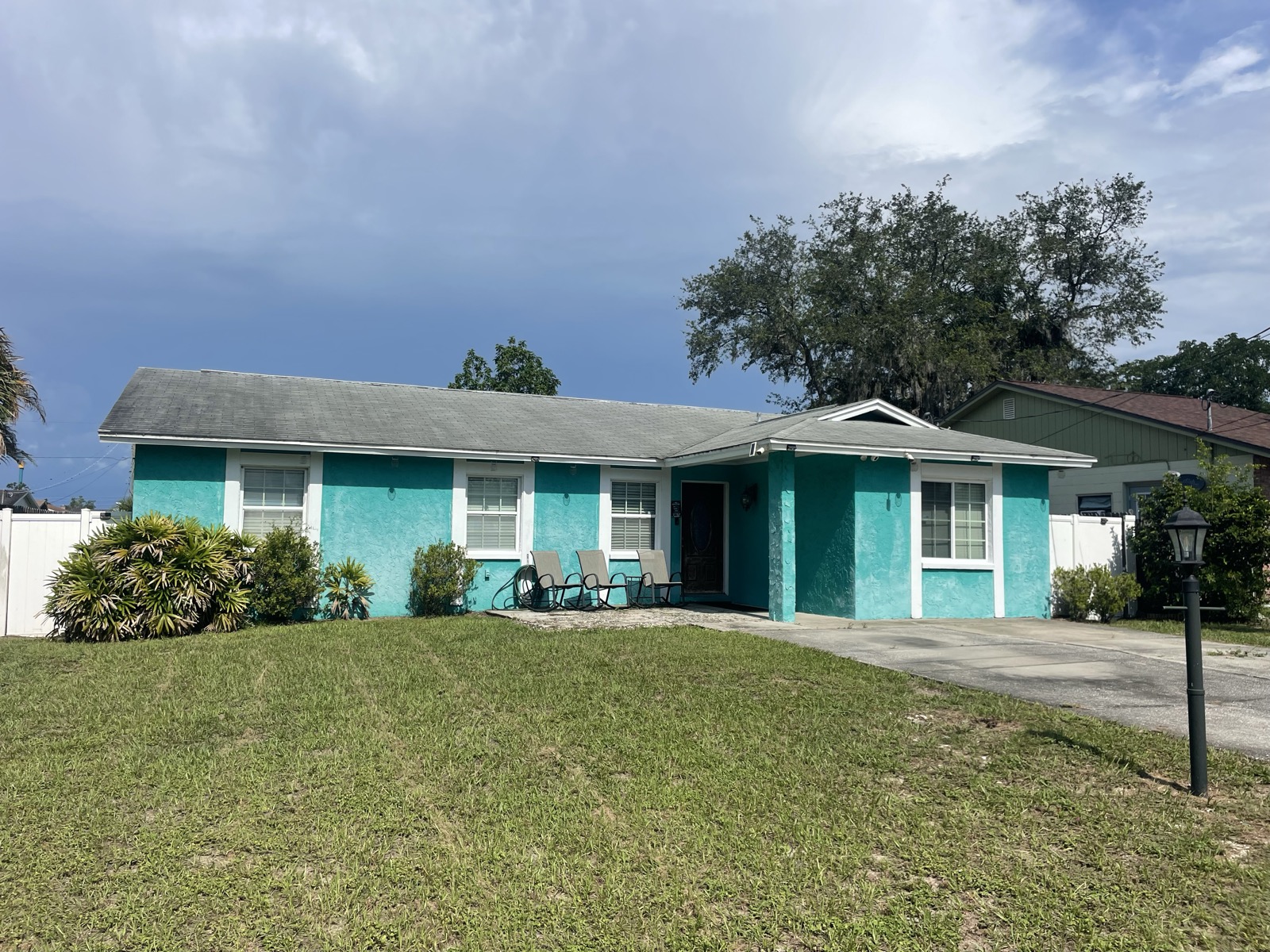 Turquoise single-story home with fresh exterior paint