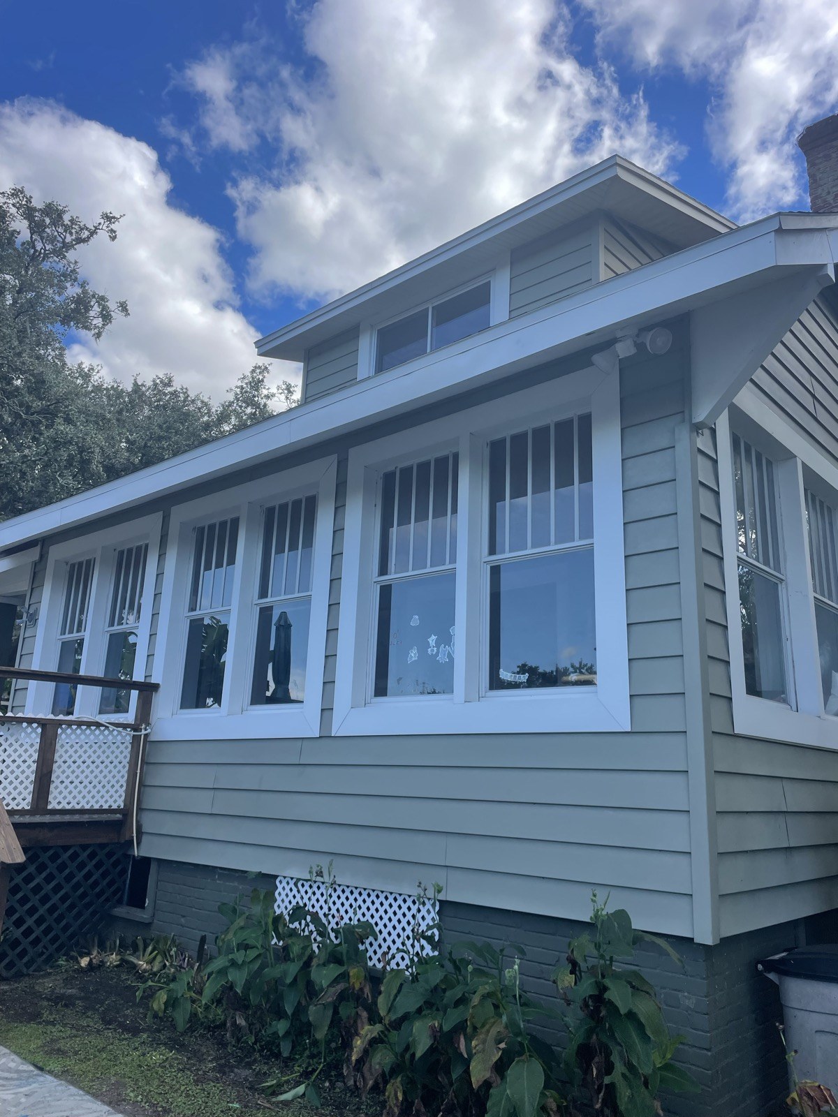 Sage bungalow with crisp white trim after power washing