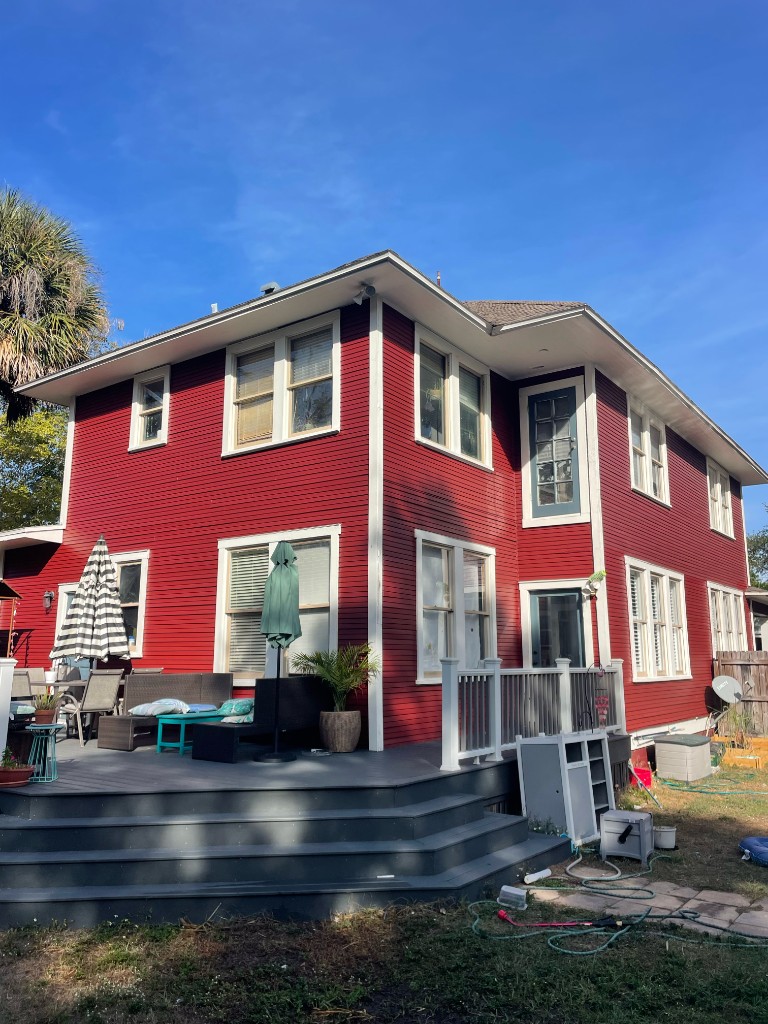 Bold red two-story home with crisp white trim